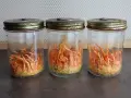 Trois bocaux en verre contiennent des cordyceps orange vif, prêts à révéler leurs bienfaits.