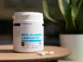Bouteille de bêta-alanine Carnosyn® pour l'endurance musculaire, avec des capsules sur une table en bois.