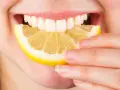 Une personne mord une tranche de citron. Est-ce que le citron est bon pour le foie ? La réponse est complexe, mais il est souvent cité pour ses bienfaits détoxifiants.