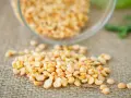 Gros plan sur des pois cassés jaunes, une excellente source de protéine de pois, renversés sur une toile de jute.