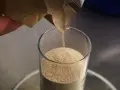 Une main verse de la levure de bière dans un verre. Découvrez les levure de bière bienfaits pour la santé.