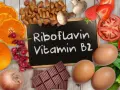 Assiette colorée avec des aliments riches en vitamine B2 : oranges, amandes, fraises, tomates, œufs, chocolat. Découvrez les vitamine b2 bienfaits !