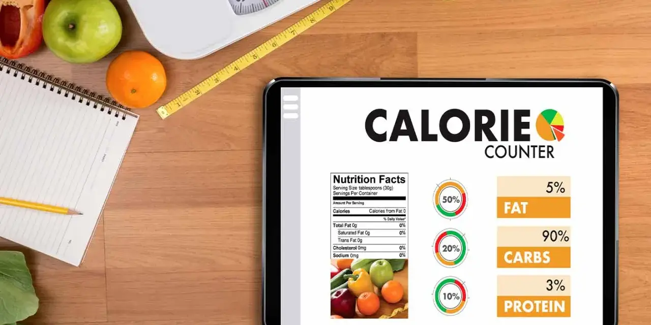 Tablette affichant un compteur de calories, avec des fruits, une balance et un mètre ruban. Aide à calculer combien de calories par jour.