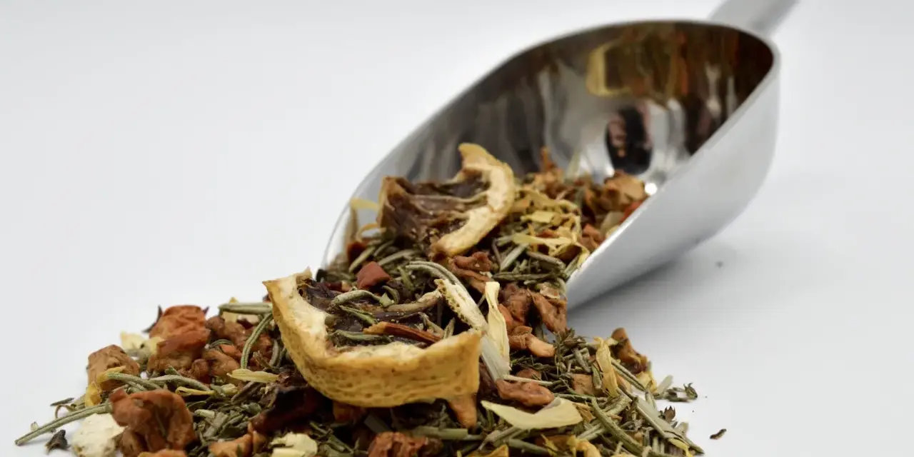 Cuillère métallique remplie d'une infusion romarin citron, aux multiples bienfaits pour la santé.