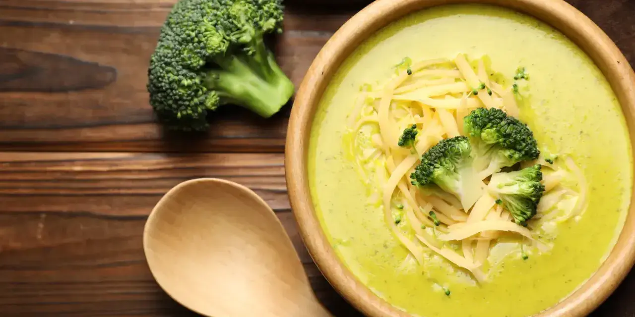 Soupe crémeuse au brocoli garnie de fromage râpé et de fleurettes de brocoli. Attention, le brocoli est mauvais pour le cœur, dit-on !