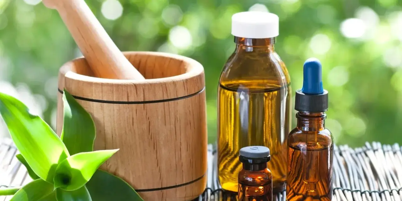 Mortier en bois, flacons d'huiles essentielles et comprimés, un remède pour la digestion à base de plantes.