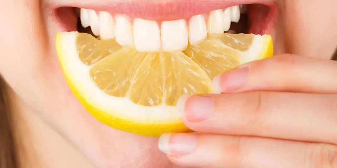 Une personne mord une tranche de citron. Est-ce que le citron est bon pour le foie ? La réponse est complexe, mais il est souvent cité pour ses bienfaits détoxifiants.