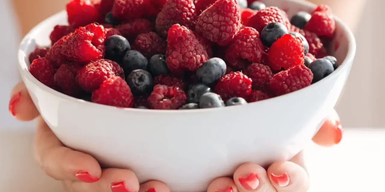 Bol rempli de framboises et myrtilles, idéal pour une alimentation légère en cas de crise de foie.
