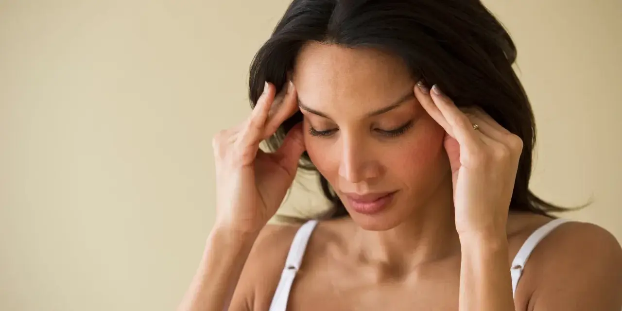 Femme se massant les tempes, cherchant à soulager une migraine en 30 secondes.