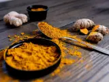 Poudre de curcuma et racines sur bois sombre. Le curcuma est connu pour ses nombreux cumin bienfaits.