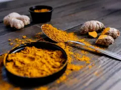 Poudre de curcuma et racines sur bois sombre. Le curcuma est connu pour ses nombreux cumin bienfaits.