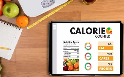 Tablette affichant un compteur de calories, avec des fruits, une balance et un mètre ruban. Aide à calculer combien de calories par jour.