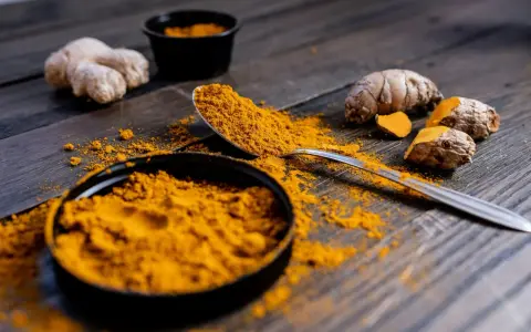 Poudre de curcuma et racines sur bois sombre. Le curcuma est connu pour ses nombreux cumin bienfaits.