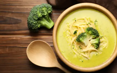Soupe crémeuse au brocoli garnie de fromage râpé et de fleurettes de brocoli. Attention, le brocoli est mauvais pour le cœur, dit-on !