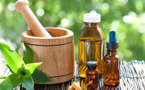 Mortier en bois, flacons d'huiles essentielles et comprimés, un remède pour la digestion à base de plantes.