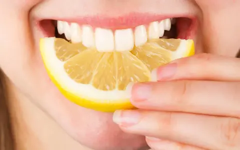 Une personne mord une tranche de citron. Est-ce que le citron est bon pour le foie ? La réponse est complexe, mais il est souvent cité pour ses bienfaits détoxifiants.
