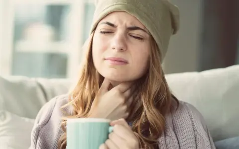 Femme souffrant d'extinction de voix, cherchant un remède miracle avec une tasse chaude.