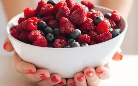Bol rempli de framboises et myrtilles, idéal pour une alimentation légère en cas de crise de foie.