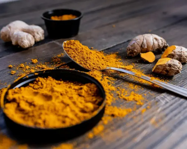 Poudre de curcuma et racines sur bois sombre. Le curcuma est connu pour ses nombreux cumin bienfaits.