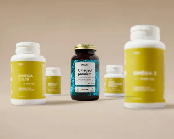 Plusieurs flacons de compléments alimentaires, dont un Oméga-3 premium, sont présentés sur un fond neutre.