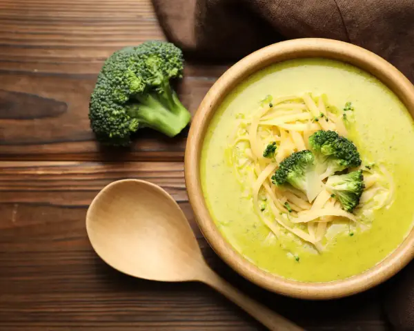 Soupe crémeuse au brocoli garnie de fromage râpé et de fleurettes de brocoli. Attention, le brocoli est mauvais pour le cœur, dit-on !