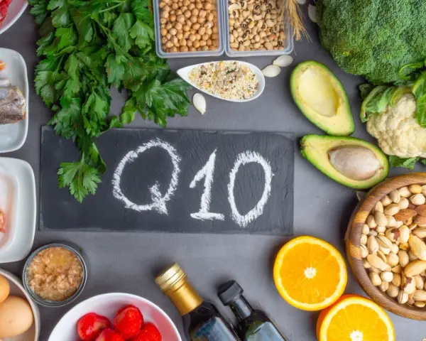 Assortiment d'aliments riches en coenzyme Q10 bienfaits : poisson, poulet, œufs, avocats, brocolis, oranges, noix, graines.