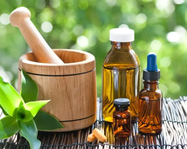 Mortier en bois, flacons d'huiles essentielles et comprimés, un remède pour la digestion à base de plantes.