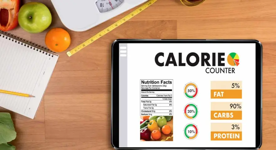 Tablette affichant un compteur de calories, avec des fruits, une balance et un mètre ruban. Aide à calculer combien de calories par jour.