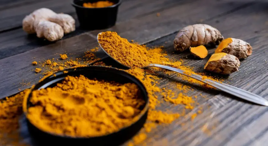 Poudre de curcuma et racines sur bois sombre. Le curcuma est connu pour ses nombreux cumin bienfaits.