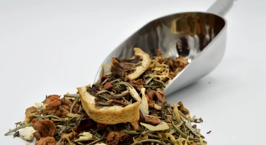 Cuillère métallique remplie d'une infusion romarin citron, aux multiples bienfaits pour la santé.