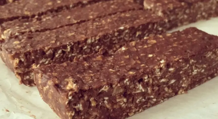 Barres chocolatées maison, parfaites pour une recette barre protéinée whey. Elles sont faites d'avoine, de cacao et de noix.