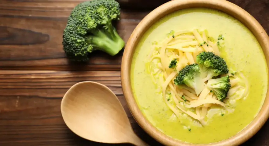 Soupe crémeuse au brocoli garnie de fromage râpé et de fleurettes de brocoli. Attention, le brocoli est mauvais pour le cœur, dit-on !