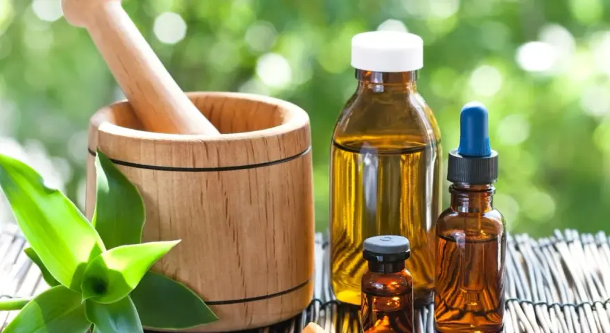 Mortier en bois, flacons d'huiles essentielles et comprimés, un remède pour la digestion à base de plantes.