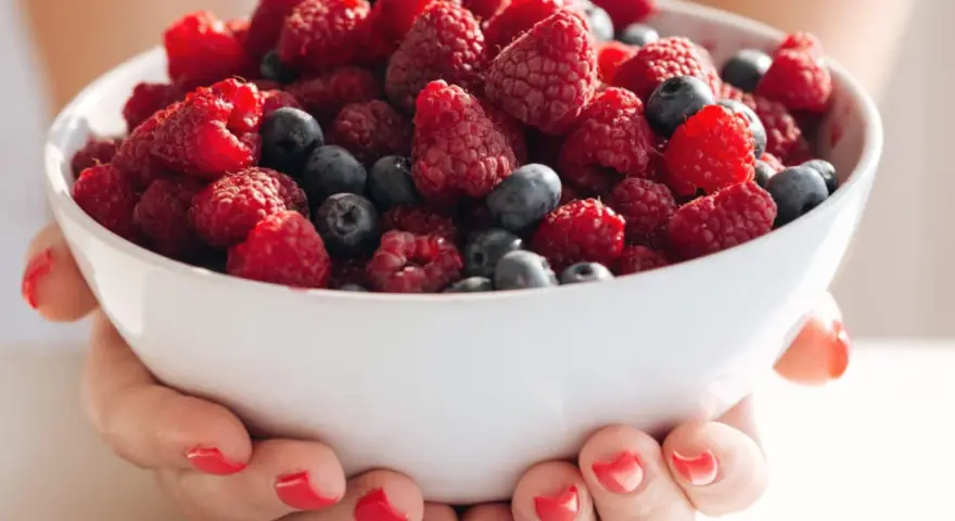 Bol rempli de framboises et myrtilles, idéal pour une alimentation légère en cas de crise de foie.