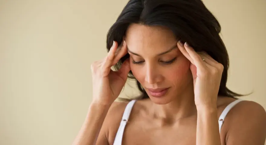 Femme se massant les tempes, cherchant à soulager une migraine en 30 secondes.