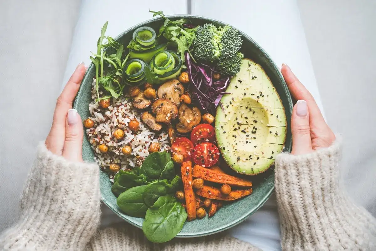 Un bol coloré avec riz, pois chiches, champignons, avocat, brocolis et légumes. Idéal pour une alimentation légère en cas de crise de foie que manger.