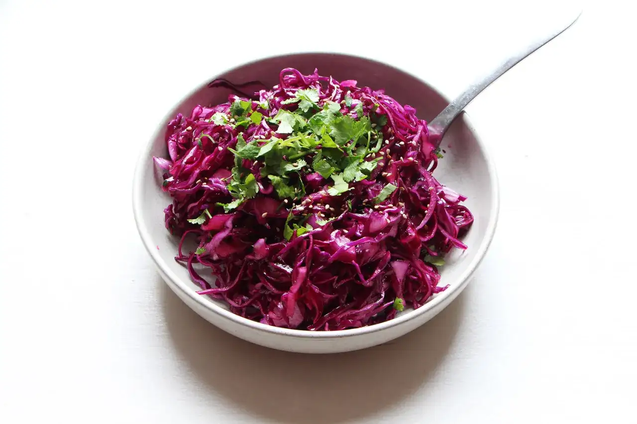 Salade color&eacute;e de chou rouge, garnie de coriandre fra&icirc;che et de graines de s&eacute;same. Un plat savoureux qui met en avant les chou rouge bienfaits.