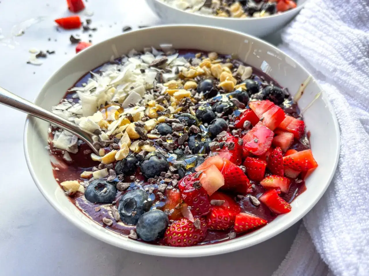 Un bol color&eacute; de smoothie acai, garni de fraises, myrtilles, noix et noix de coco r&acirc;p&eacute;e. Un d&eacute;lice fruit&eacute; !